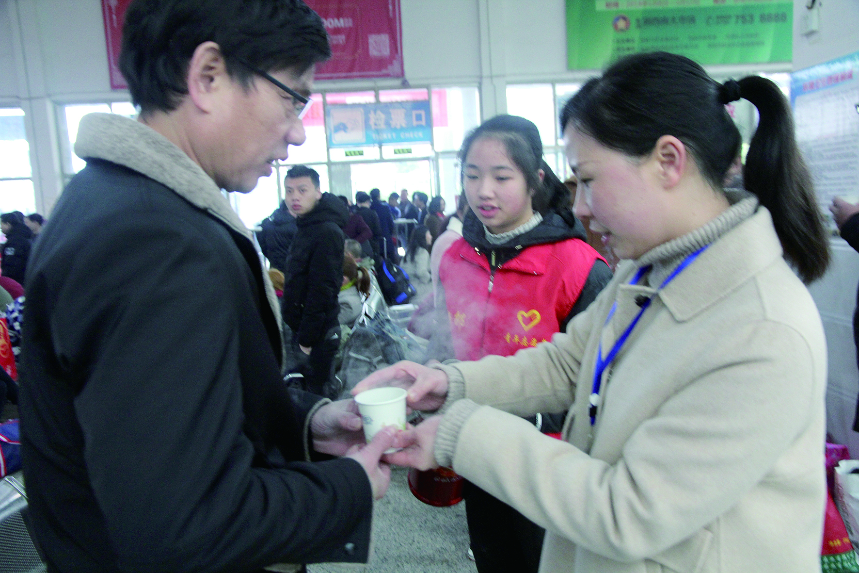 母女服務(wù)春運(yùn) 2月13日，記者在新邵分公司汽車站看到，該分公司安全科副科長(zhǎng)李喜梅與其在新邵一中初中部1701班就讀女兒劉嘉怡在車站擔(dān)當(dāng)志愿者。李喜梅在候車室耐心為旅客釋疑解惑，劉嘉怡為旅客遞上一杯杯熱茶，有時(shí)母女也相互合作，其樂融融。 祖冠 攝影報(bào)道